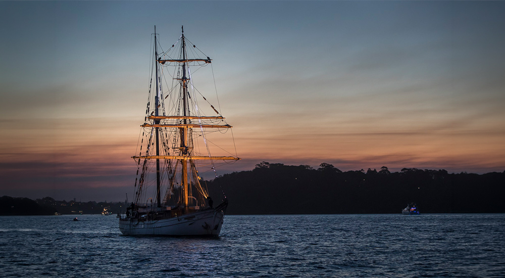 Tall ship with masts against the twilight sky on a Sydney Harbour dinner cruise